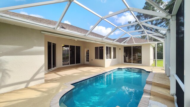 5170 NW Aljo Ct, Port Saint Lucie, FL 34986 - rear view of house featuring stucco siding, a patio, a shingled roof, and an outdoor pool