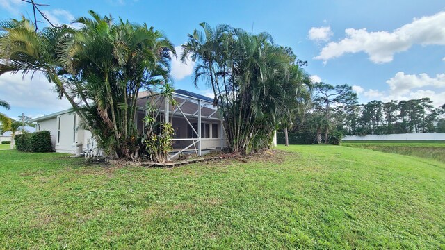 5170 NW Aljo Ct, Port Saint Lucie, FL 34986 - view of grassy yard with glass enclosure