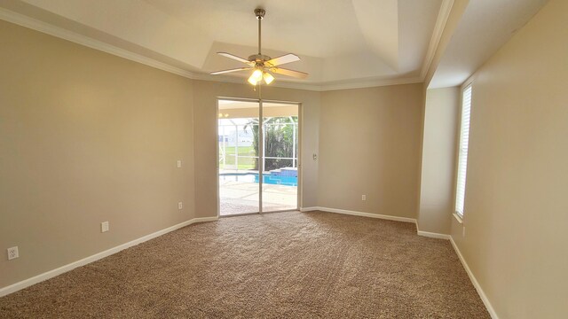 5170 NW Aljo Ct, Port Saint Lucie, FL 34986 - unfurnished room featuring a raised ceiling, ceiling fan, carpet, crown molding, and baseboards
