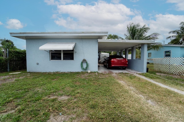 1214 Peak Rd, Lantana, FL 33462 - view of side of home featuring stucco siding, a carport, and driveway