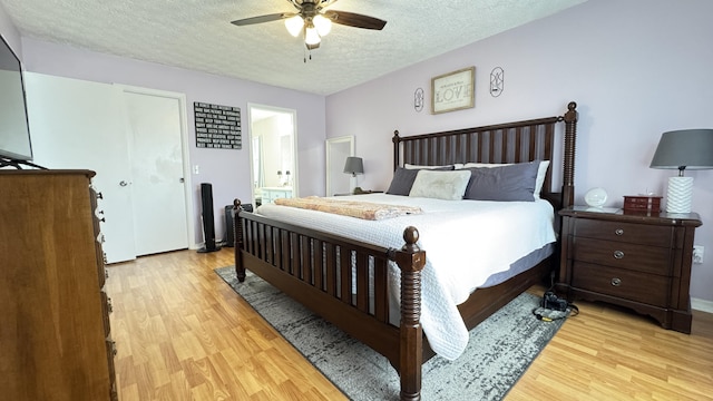 507 NW Azalea Ave, Port Saint Lucie, FL 34983 - bedroom featuring light wood finished floors, a textured ceiling, a ceiling fan, and connected bathroom