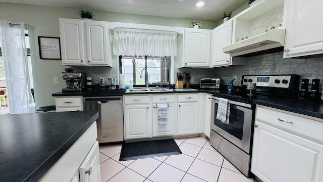 507 NW Azalea Ave, Port Saint Lucie, FL 34983 - kitchen with appliances with stainless steel finishes, under cabinet range hood, a sink, dark countertops, and recessed lighting