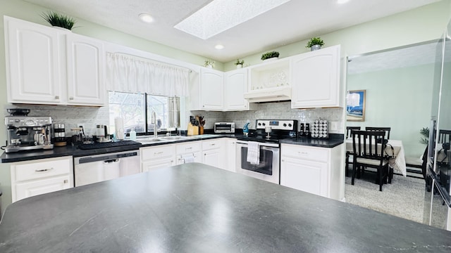 507 NW Azalea Ave, Port Saint Lucie, FL 34983 - kitchen with appliances with stainless steel finishes, under cabinet range hood, a sink, dark countertops, and white cabinets