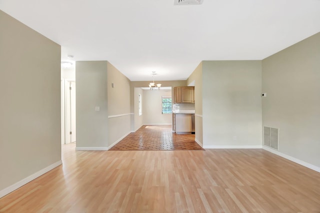 1103 NW 7th Ct, Boynton Beach, FL 33426 - unfurnished living room featuring a chandelier, light wood-style floors, and baseboards