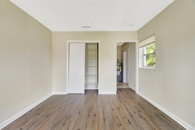 1103 NW 7th Ct, Boynton Beach, FL 33426 - unfurnished bedroom featuring electric water heater, wood finished floors, a closet, and baseboards