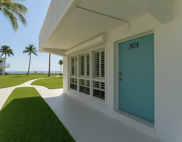 1470 S Ocean Blvd Unit 301, Pompano Beach, FL 33062 - view of exterior entry featuring a water view and a yard