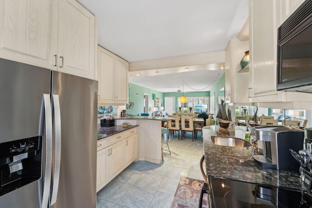 1470 S Ocean Blvd Unit 301, Pompano Beach, FL 33062 - kitchen featuring black appliances, a sink, dark stone counters, and a peninsula