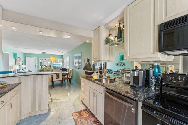 1470 S Ocean Blvd Unit 301, Pompano Beach, FL 33062 - kitchen featuring black appliances, a sink, dark stone counters, cream cabinets, and open floor plan