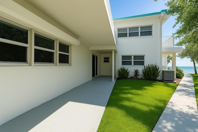 1470 S Ocean Blvd Unit 301, Pompano Beach, FL 33062 - property entrance featuring stucco siding, central AC unit, a lawn, a water view, and a patio