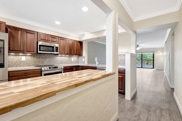 3118 Florida Blvd Unit 204-B, Delray Beach, FL 33483 - kitchen featuring wooden counters, stainless steel appliances, backsplash, light wood-style floors, and crown molding
