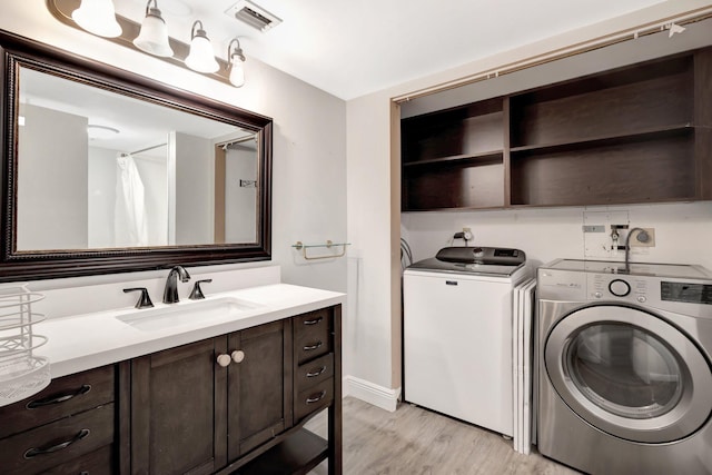 3118 Florida Blvd Unit 204-B, Delray Beach, FL 33483 - laundry room with washer and dryer, a sink, and light wood-type flooring