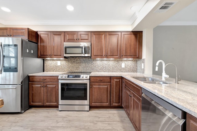 3118 Florida Blvd Unit 204-B, Delray Beach, FL 33483 - kitchen featuring appliances with stainless steel finishes, a sink, crown molding, light stone countertops, and light wood-style flooring