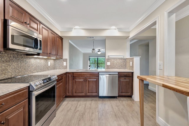 3118 Florida Blvd Unit 204-B, Delray Beach, FL 33483 - kitchen with stainless steel appliances, a sink, light wood-style flooring, ornamental molding, and backsplash
