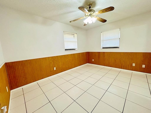 2657 River Rd, Moore Haven, FL 33471 - spare room featuring wainscoting, wood walls, a textured ceiling, and ceiling fan