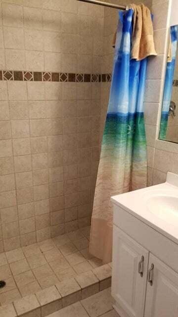 1512 Florida Ave Unit 1/2, West Palm Beach, FL 33401 - bathroom with vanity, tiled shower, and tile patterned flooring