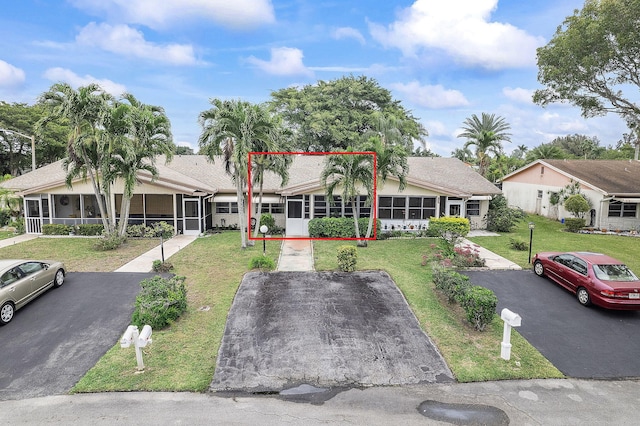 14444 Campanelli Dr, Delray Beach, FL 33484 - view of front facade featuring a sunroom and a front yard
