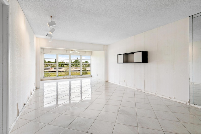 5606 Via Delray Unit B, Delray Beach, FL 33484 - unfurnished room featuring a textured ceiling, light tile patterned floors, rail lighting, and a ceiling fan