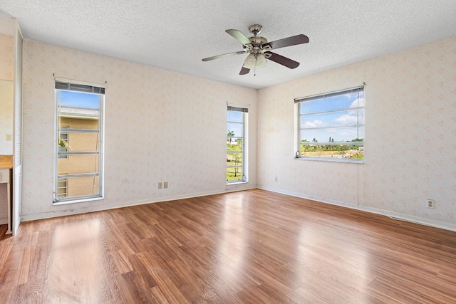 5606 Via Delray Unit B, Delray Beach, FL 33484 - spare room with wood finished floors, wallpapered walls, a textured ceiling, plenty of natural light, and ceiling fan