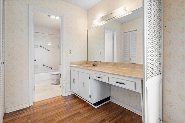 5606 Via Delray Unit B, Delray Beach, FL 33484 - full bath with toilet, wood finished floors, vanity, wallpapered walls, and washtub / shower combination