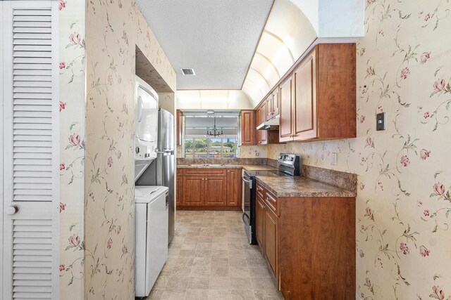 5606 Via Delray Unit B, Delray Beach, FL 33484 - kitchen with stainless steel range with electric cooktop, under cabinet range hood, brown cabinets, a sink, and a textured ceiling