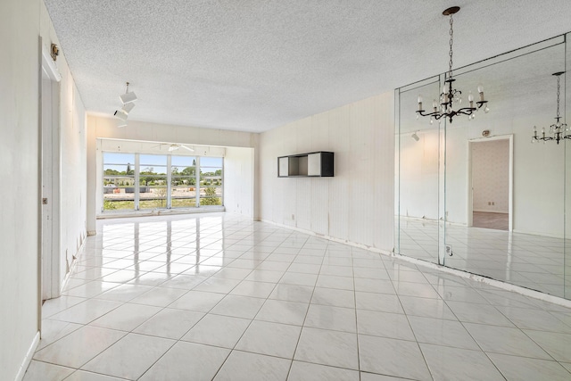 5606 Via Delray Unit B, Delray Beach, FL 33484 - empty room with a chandelier, a textured ceiling, and light tile patterned floors