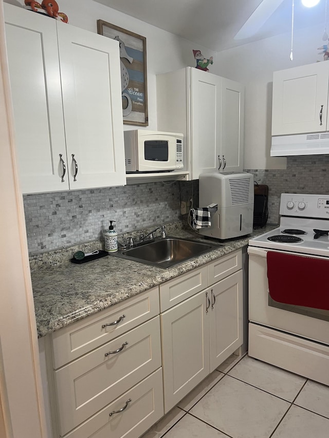 132 Berkshire F, West Palm Beach, FL 33417 - kitchen with white appliances, under cabinet range hood, a sink, white cabinets, and tasteful backsplash
