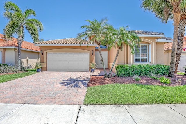 7703 Caprio Dr, Boynton Beach, FL 33472 - mediterranean / spanish-style home with decorative driveway, stucco siding, a garage, and a tile roof