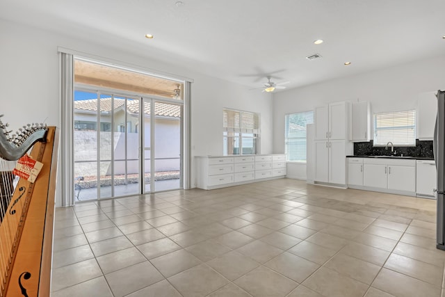 7703 Caprio Dr, Boynton Beach, FL 33472 - unfurnished living room featuring ceiling fan, light tile patterned flooring, a sink, and recessed lighting