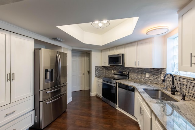 103 Weybridge C Cir Unit C, Royal Palm Beach, FL 33411 - kitchen with appliances with stainless steel finishes, backsplash, dark wood-style floors, light stone counters, and a tray ceiling