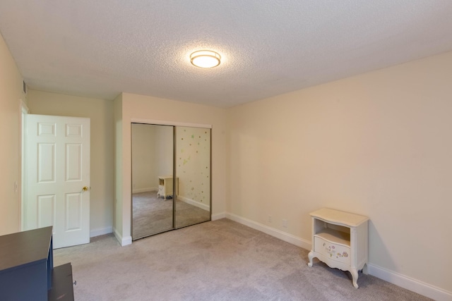 103 Weybridge C Cir Unit C, Royal Palm Beach, FL 33411 - unfurnished bedroom with light carpet, a closet, and a textured ceiling