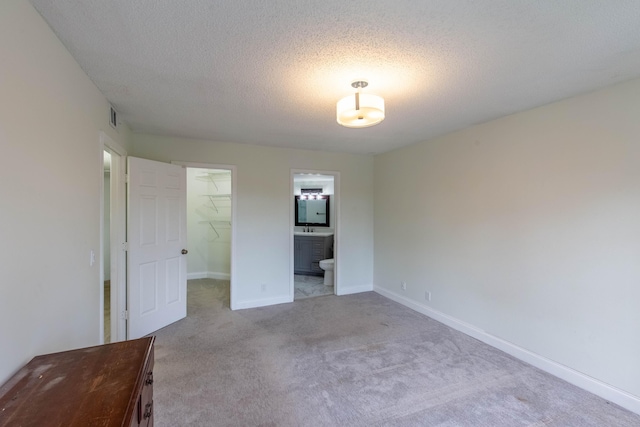 103 Weybridge C Cir Unit C, Royal Palm Beach, FL 33411 - unfurnished bedroom featuring light colored carpet, a spacious closet, a textured ceiling, a closet, and ensuite bathroom