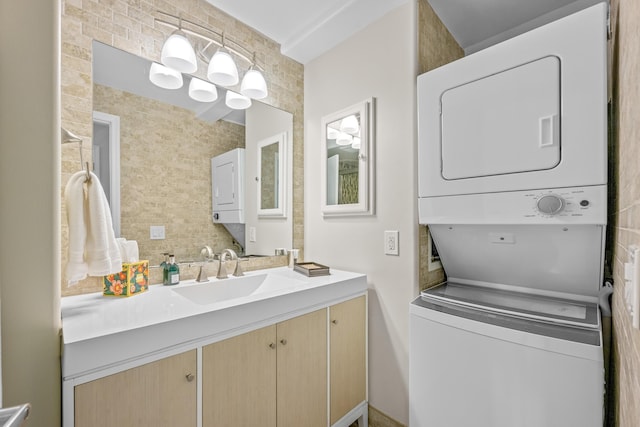112 Piedmont C, Delray Beach, FL 33484 - bathroom featuring stacked washing machine and dryer, vanity, and tasteful backsplash
