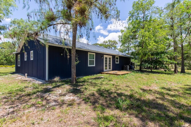 16932 W Aintree Dr W, Loxahatchee, FL 33470 - rear view of house with french doors, board and batten siding, a yard, and central AC unit