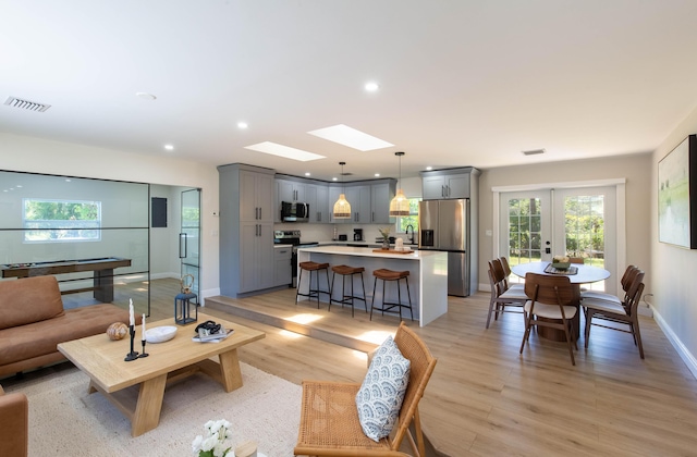 16932 W Aintree Dr W, Loxahatchee, FL 33470 - living area with light wood-style floors, french doors, baseboards, recessed lighting, and a skylight
