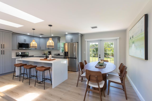 16932 W Aintree Dr W, Loxahatchee, FL 33470 - kitchen with stainless steel appliances, light countertops, a center island, gray cabinets, and french doors