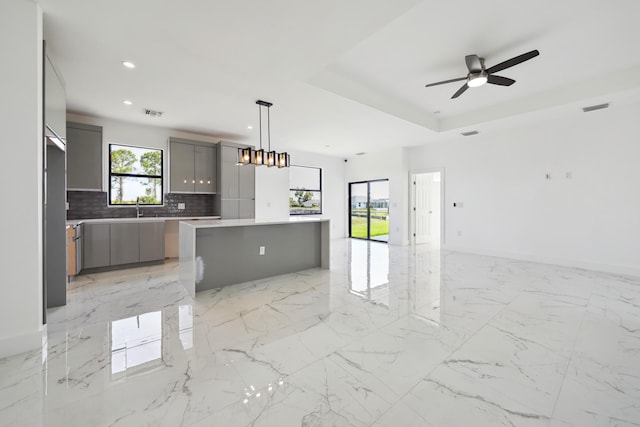 418 NE 31st Ter, Cape Coral, FL 33909 - kitchen featuring gray cabinetry, open floor plan, decorative backsplash, a center island, and recessed lighting