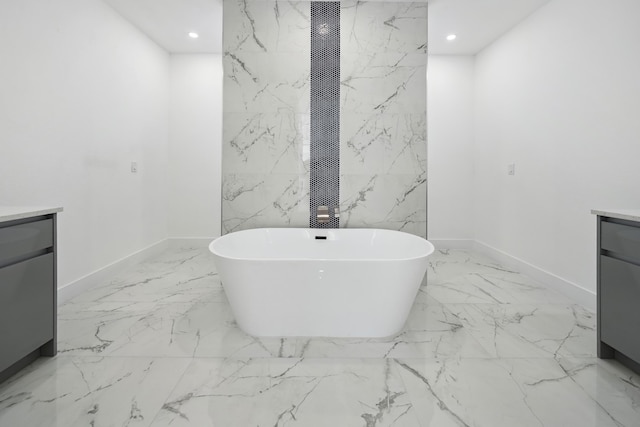 418 NE 31st Ter, Cape Coral, FL 33909 - full bath featuring vanity, marble finish flooring, a soaking tub, recessed lighting, and baseboards