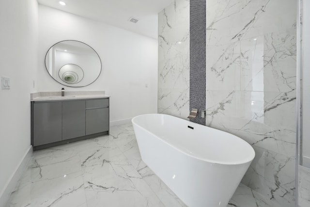 418 NE 31st Ter, Cape Coral, FL 33909 - bathroom featuring marble tiled flooring, vanity, a freestanding tub, baseboards, and recessed lighting