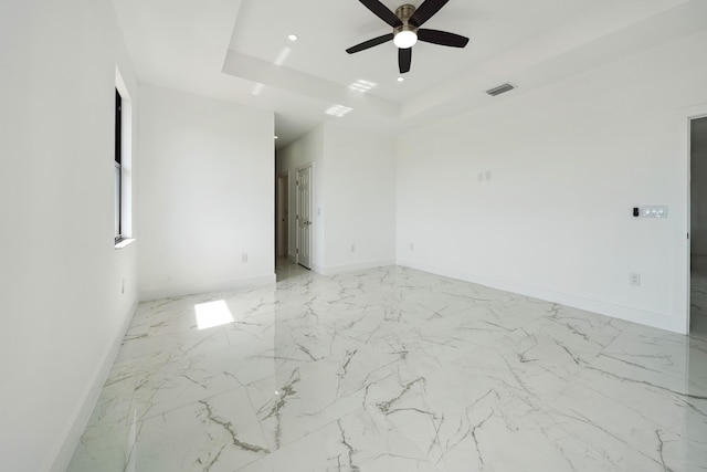 418 NE 31st Ter, Cape Coral, FL 33909 - empty room with baseboards, ceiling fan, a tray ceiling, recessed lighting, and light marble finish flooring