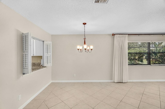 1801 Indian River Blvd Unit B8, Vero Beach, FL 32960 - unfurnished room with a chandelier, a textured ceiling, light tile patterned floors, and baseboards