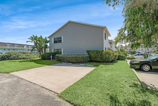 1801 Indian River Blvd Unit B8, Vero Beach, FL 32960 - view of side of property featuring a yard, stucco siding, and uncovered parking