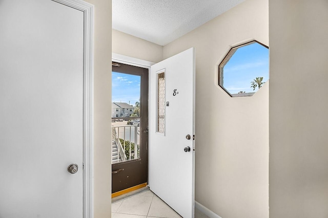 1801 Indian River Blvd Unit B8, Vero Beach, FL 32960 - entryway with plenty of natural light, light tile patterned floors, baseboards, and a textured ceiling