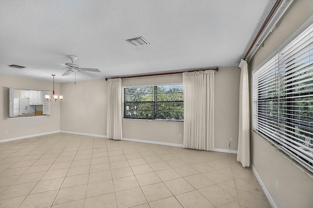 1801 Indian River Blvd Unit B8, Vero Beach, FL 32960 - empty room featuring a chandelier, a textured ceiling, a ceiling fan, baseboards, and light tile patterned floors