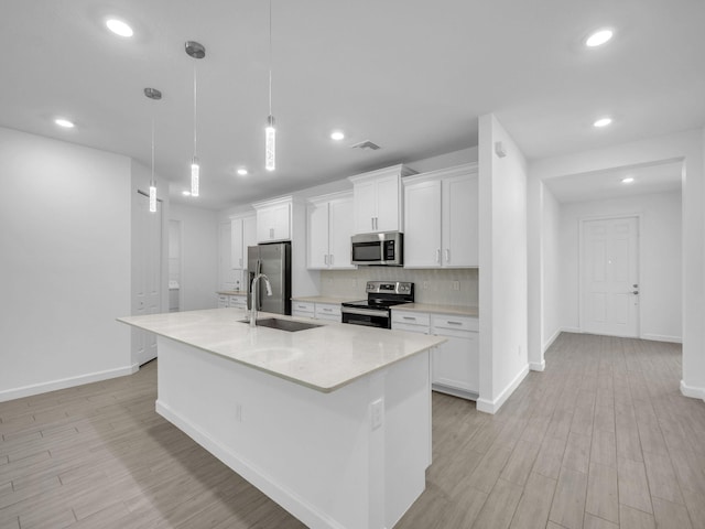 3181 Streng Ln, Royal Palm Beach, FL 33411 - kitchen with appliances with stainless steel finishes, a sink, an island with sink, white cabinetry, and recessed lighting