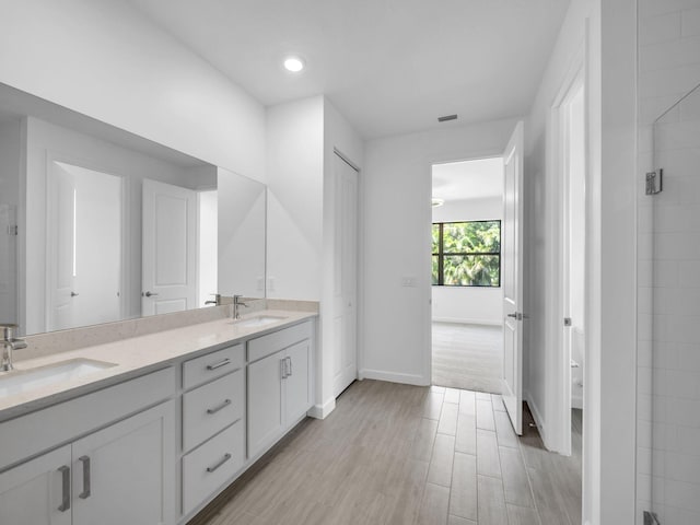 3181 Streng Ln, Royal Palm Beach, FL 33411 - full bath with double vanity, wood finished floors, baseboards, toilet, and a tile shower
