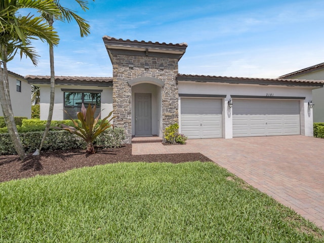 3181 Streng Ln, Royal Palm Beach, FL 33411 - mediterranean / spanish-style home with stucco siding, decorative driveway, stone siding, a tiled roof, and an attached garage