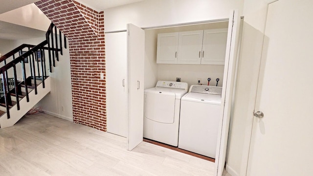 4344 Carambola Cir Unit F707, Coconut Creek, FL 33066 - laundry area with cabinet space, washing machine and dryer, light wood-style floors, and brick wall