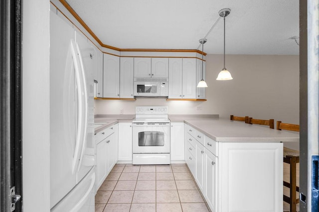 5642 SE Riverboat Dr Unit A5-120, Stuart, FL 34997 - kitchen with white appliances, a peninsula, a breakfast bar area, light countertops, and light tile patterned floors