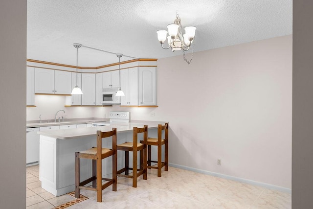 5642 SE Riverboat Dr Unit A5-120, Stuart, FL 34997 - kitchen featuring white appliances, light countertops, a chandelier, a textured ceiling, and a peninsula