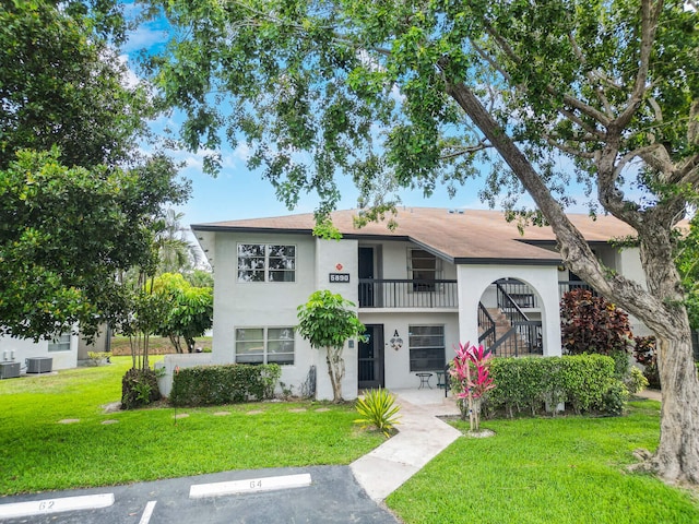 5890 Sugar Palm Ct Unit E, Delray Beach, FL 33484 - townhome / multi-family property featuring stucco siding, a front yard, a balcony, and uncovered parking